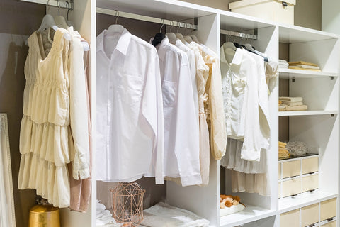 a closet full of shirts and short dresses in spring colours