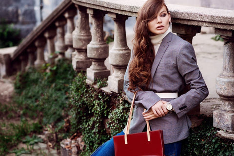 a stylish woman wearing a white belt over a large grey blazer