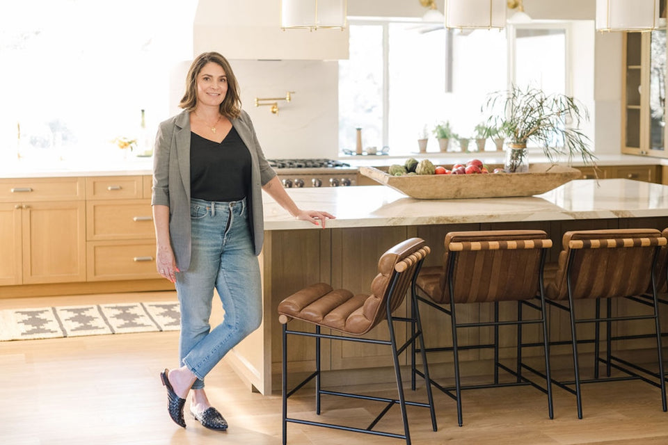 Elsa standing by the kitchen island in a spacious sunny kitchen
