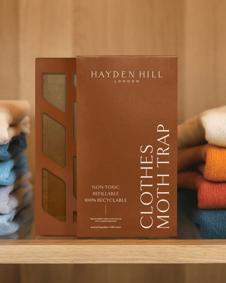 a Hayden Hill moth trap in place on a shelf between two piles of coloured sweaters
