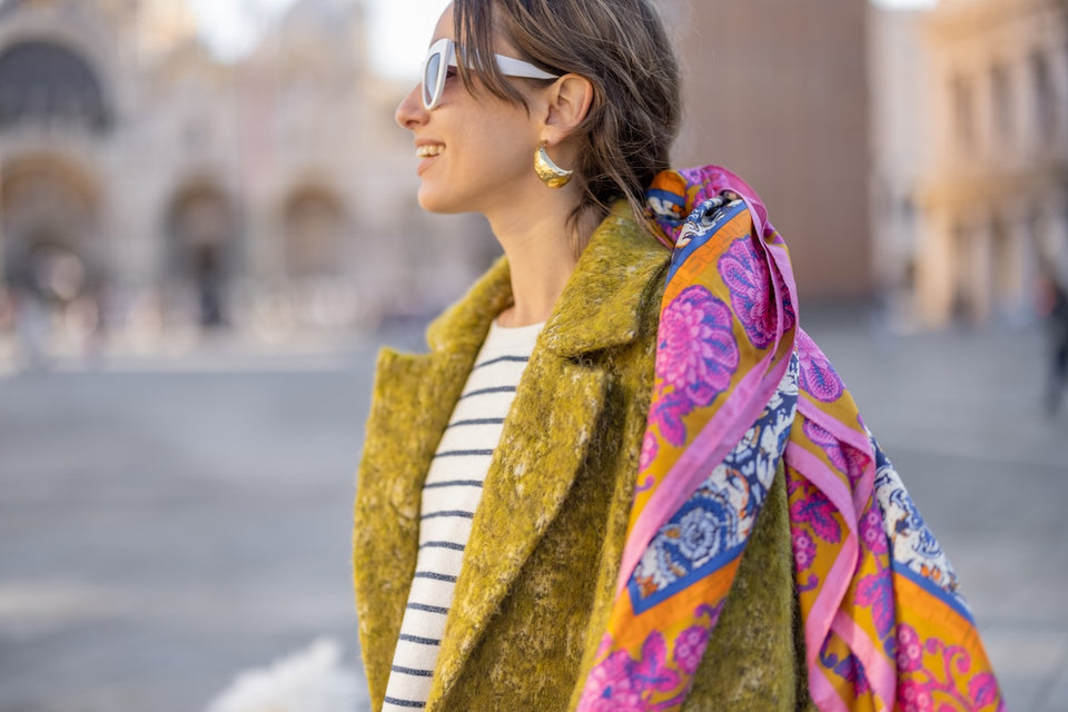 a woman wearing a lime green wool coat with a brightly patterned scarf