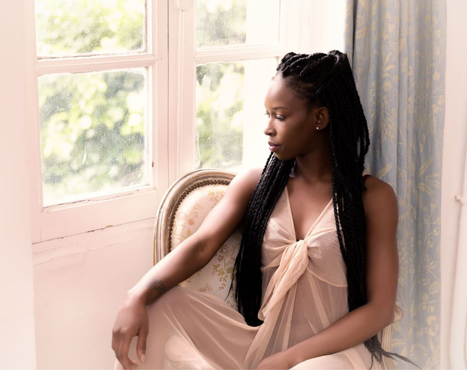 a woman sitting at her window in a beautiful long night dress