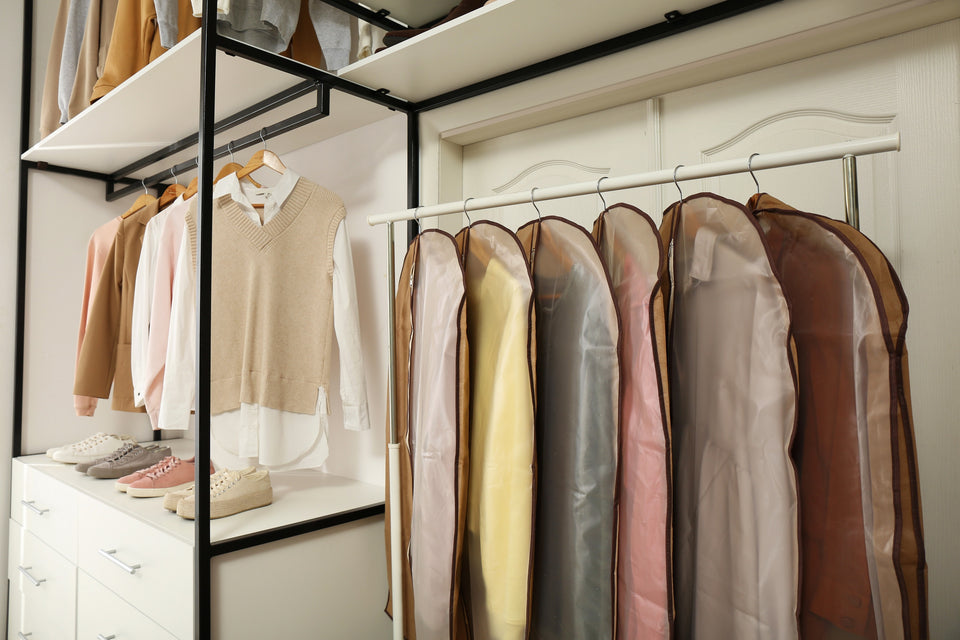 an arrangement of clothing hanging in garment bags