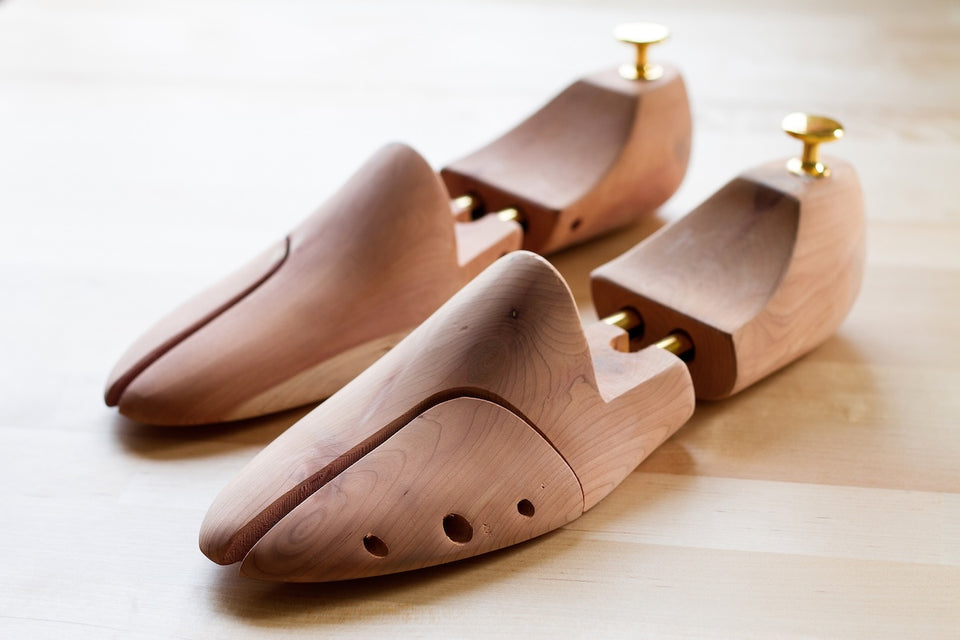 a close up of a pair of elegant cedar shoe trees for keeping trainers in good condition