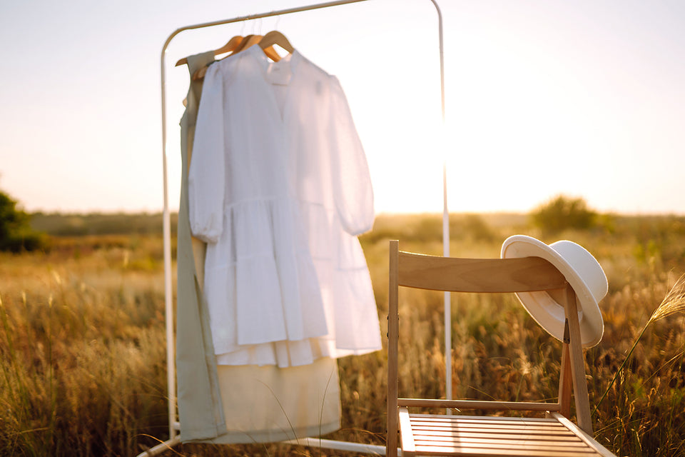 cotton and linen clothing hanging on a clothing rail in a field
