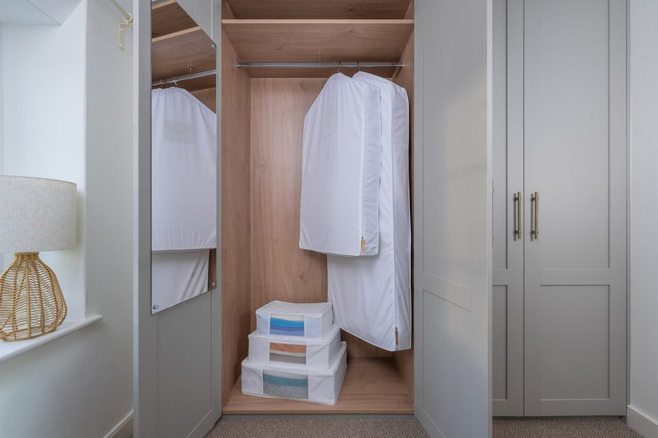 n open closet with Hayden Hill organic cotton storage and hanging bags with clothing safely protected inside