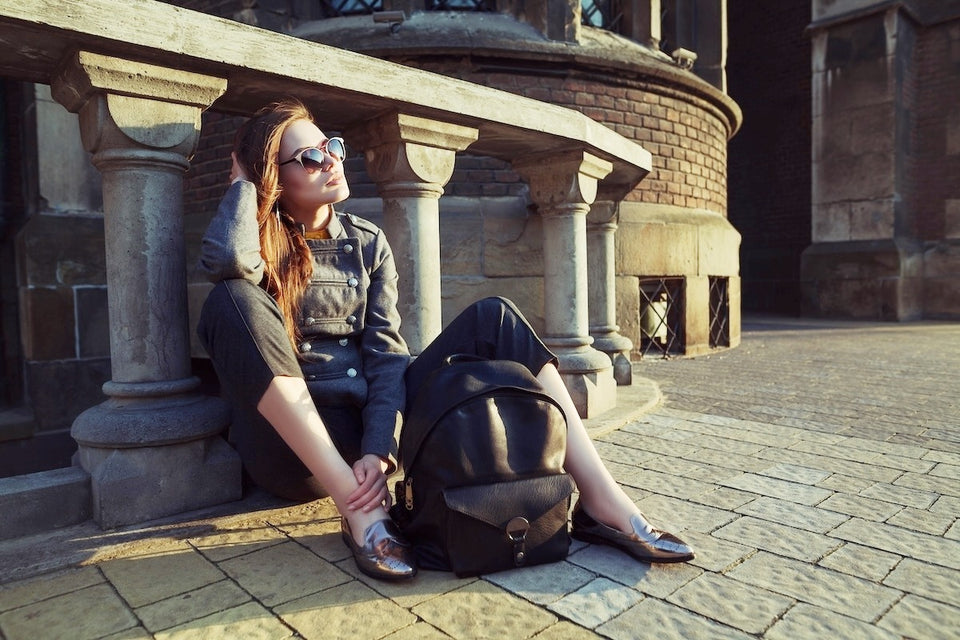 a woman in a military style jacket and cropped trousers with flat pumps