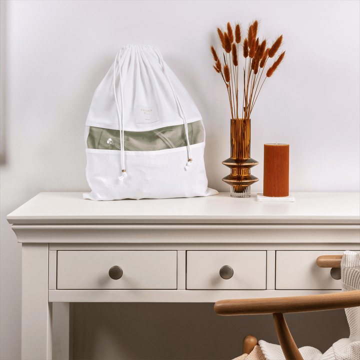 a front view of a medium dust bag sitting on a dressing table