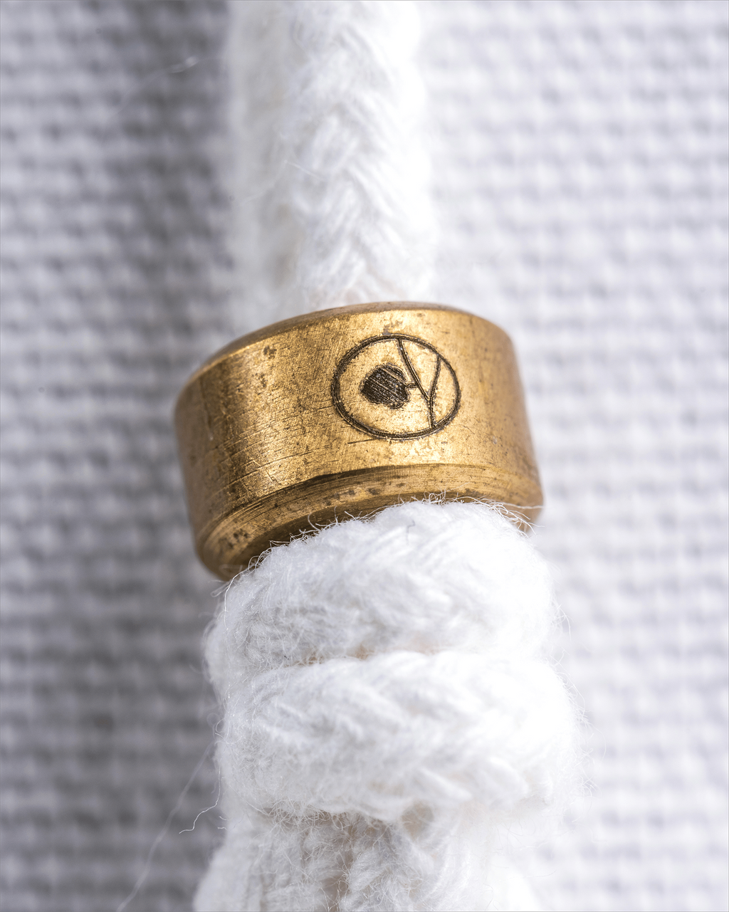 a close up of the Hayden Hill brass slider on the draw string of a dust bag