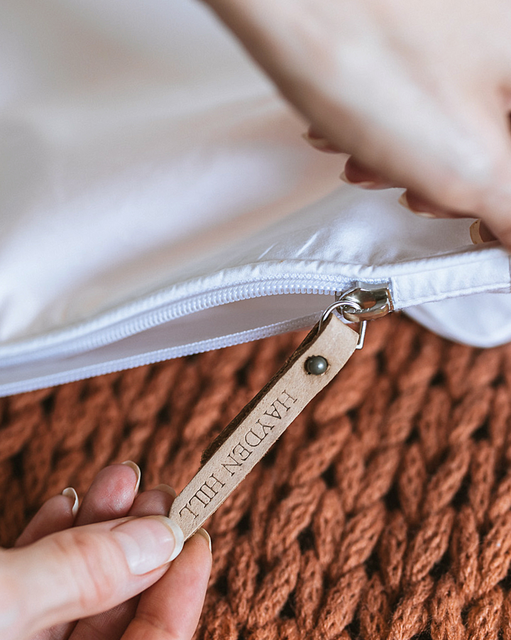 a close up of the leather zipper pull being used on a storage bag