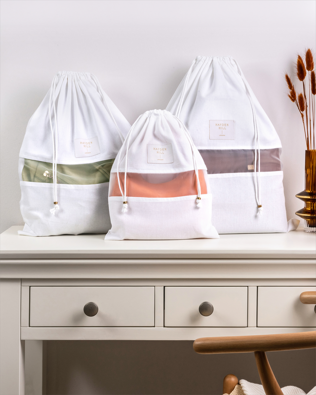 a small, medium and large size dust bag sitting on a dressing table