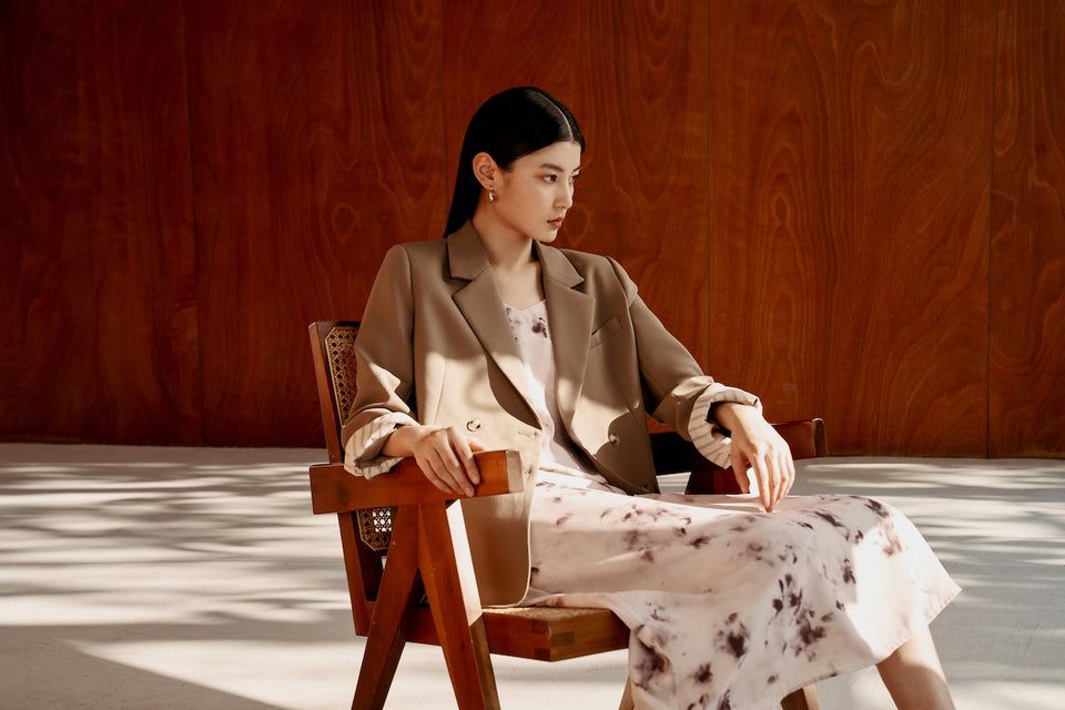 a woman wearing a blazer with a floaty summer dress underneath