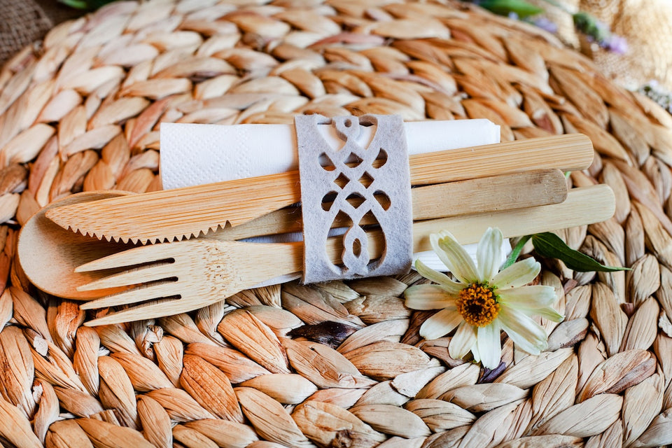 a close up of a bamboo cutlery on a woven placemat