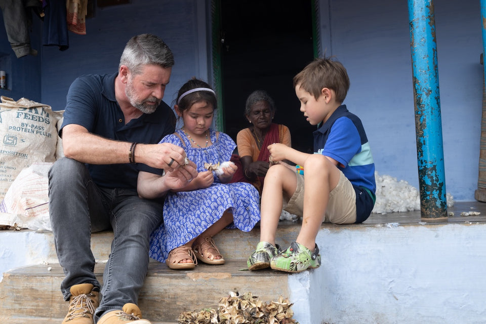 our founder, Adam, with his two children helping sort through the cotton bolls
