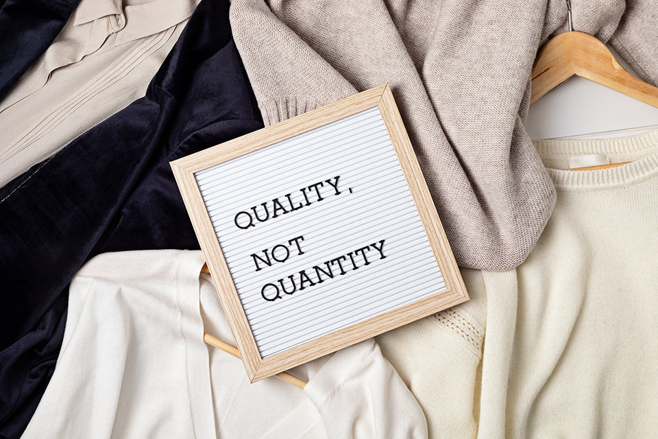 the mission statement ‘Quality, Not Quantity’ placed on top of a pile of sweaters and clothing