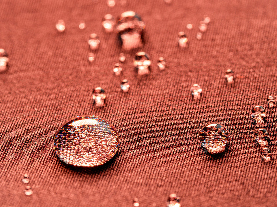 water droplets on rust colored waterproof fabric