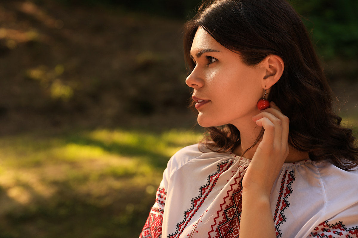 a beautiful woman wearing an embroidered top