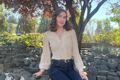Marley wearing a 1940’s inspired outfit pairing a cream shirt with a front yoke and dark blue denim jeans