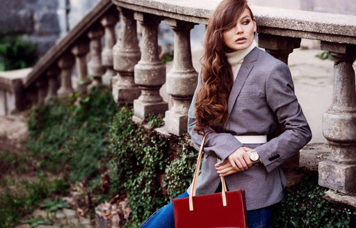 a stylish woman wearing a white belt over a large grey blazer