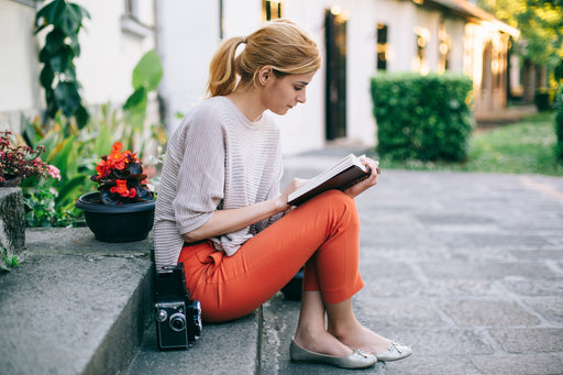 a woman sitting on steps reading a book