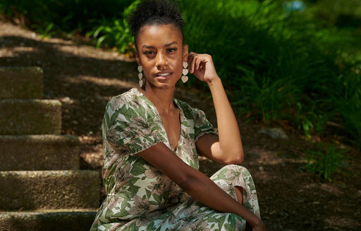 a woman wearing a green white and pink floral patterned dress