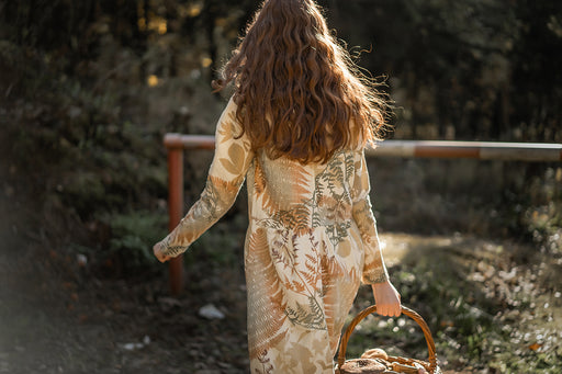 a woman wearing a patterned thick linen dress in winter sunshine