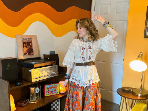 Emily dancing and playing vinyl on a turntable in a retro living room