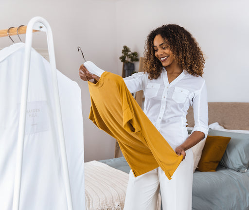 Lady preparing to store her cherished top in a Hayden Hill Garment Bag