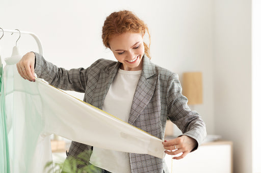 a Tailor measuring the sleeve on a white shirt