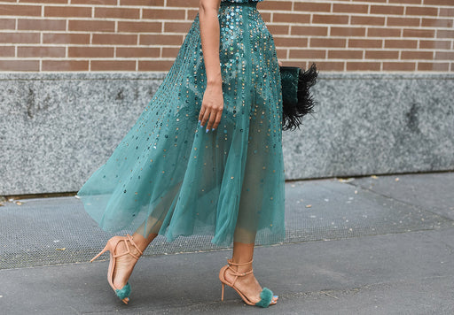 a beautiful pair of tan and green high-heeled sandals matched with a sparkly tulle green evening dress
