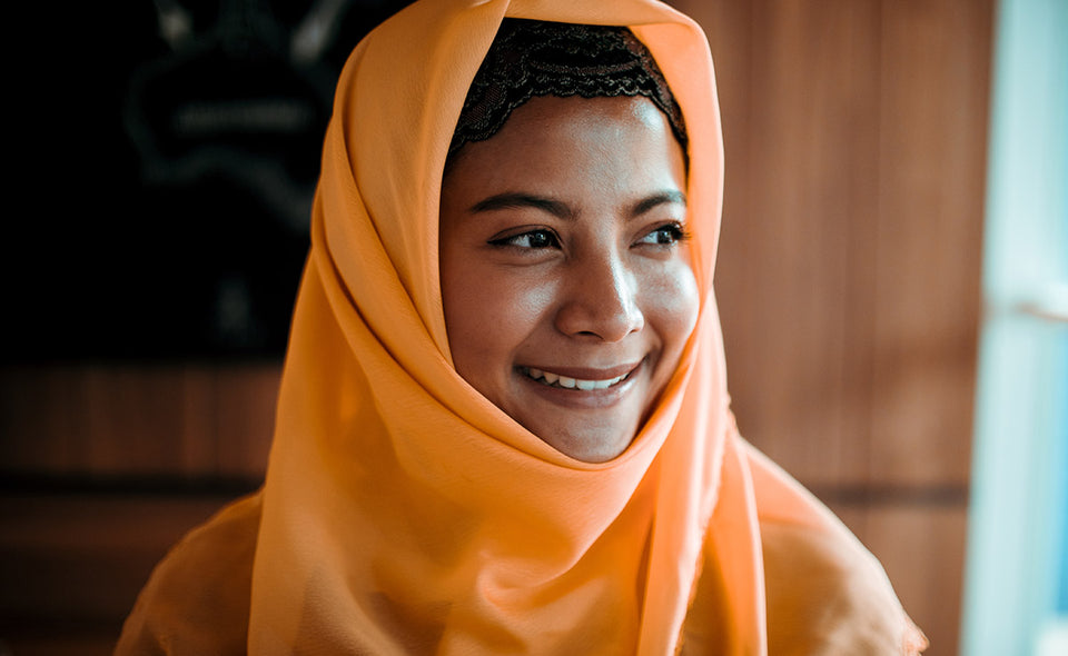 a beautiful woman wearing a pale orange headscarf