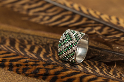 a bespoke silver ring with green gemstones