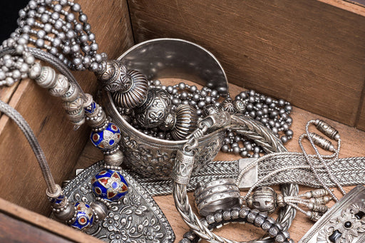a box full of silver ethnic bracelets and necklaces
