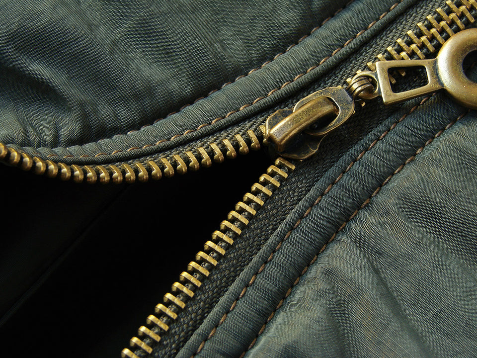 a brass zip on a raincoat