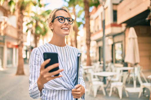 a businesswoman wearing a striped cotton shirt walking past coffee shops