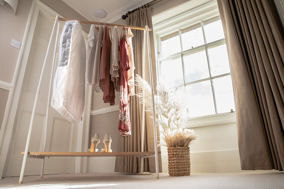 a capsule collection of clothing on a hanging rail