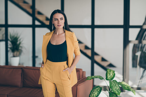 a chic woman wearing a neatly ironed yellow trouser suit