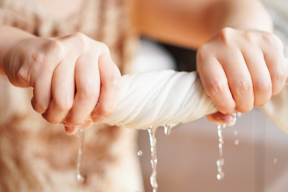a close up of wringing out a piece of handwashing