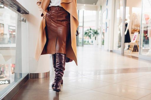 a crop image of a brown leather skirt and leather boots