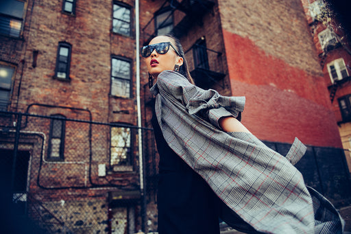 a fashionable woman in a check coat and sunglasses