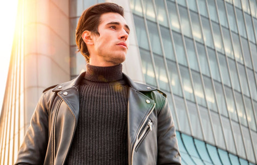 a man wearing a black leather jacket over a ribbed roll neck jumper