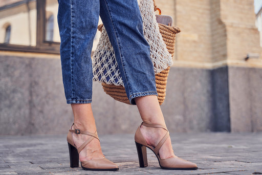 a pair of blue jeans being worn with tan heels