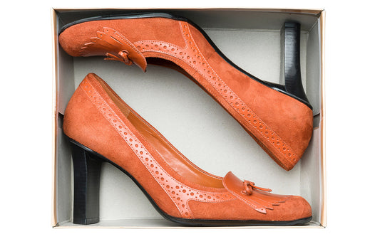 a pair of high-heeled fringed golf shoes in a shoe box