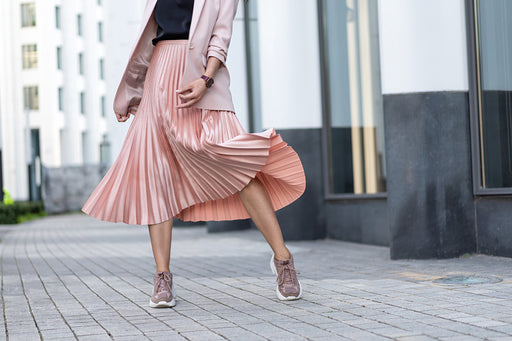 a pale pink blazer teamed with a pink satin pleated skirt