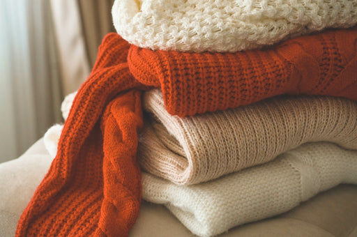 a pile of cosy woollen sweaters