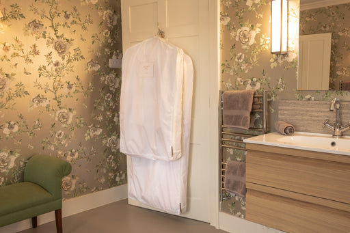 a short and long Hayden Hill garment storage bag hanging on the back of the bathroom door