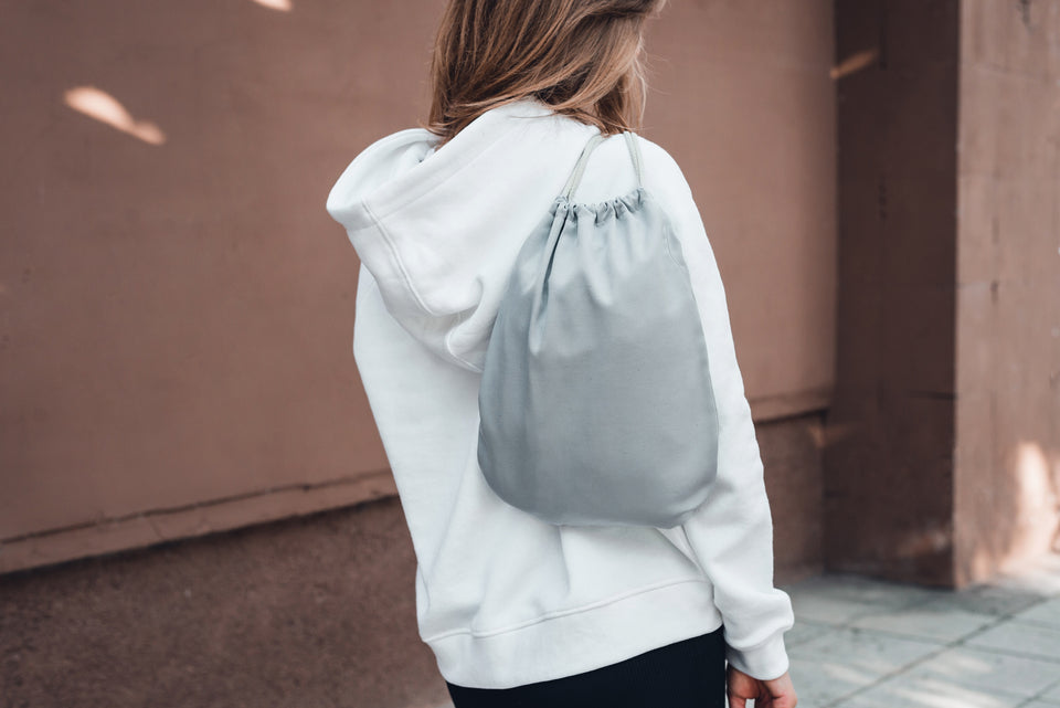 a silver gray satin dust bag worn over the shoulder