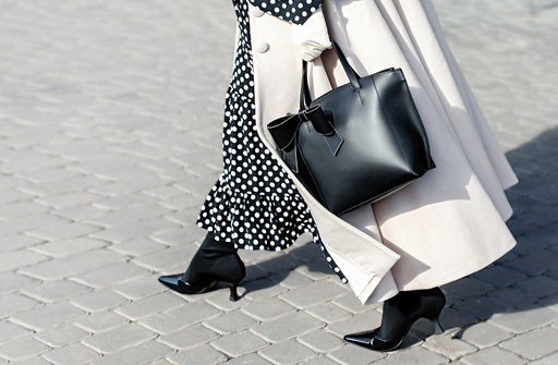 a stylish black and white polka dot skirt teamed with a white coat and black handbag