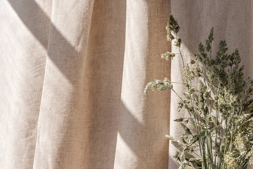 a swathe of natural unbleached cotton next to some dried grasses