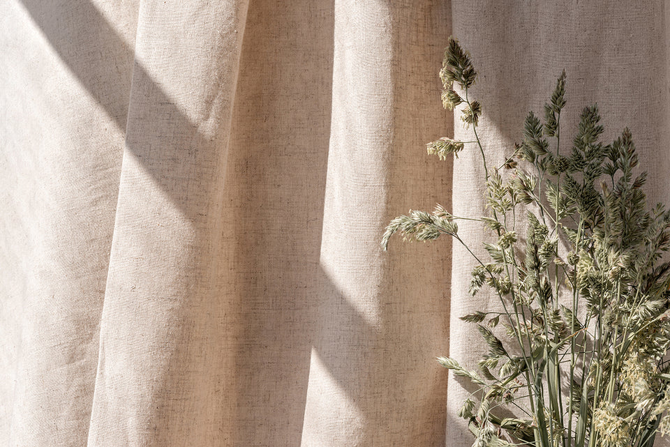 a swathe of natural unbleached cotton next to some dried grasses